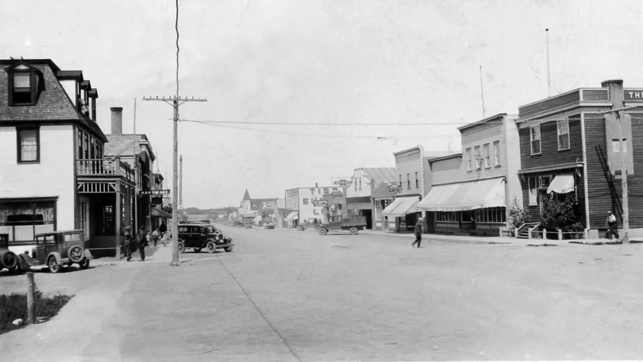 Main street with early cars and storefronts, about 1928